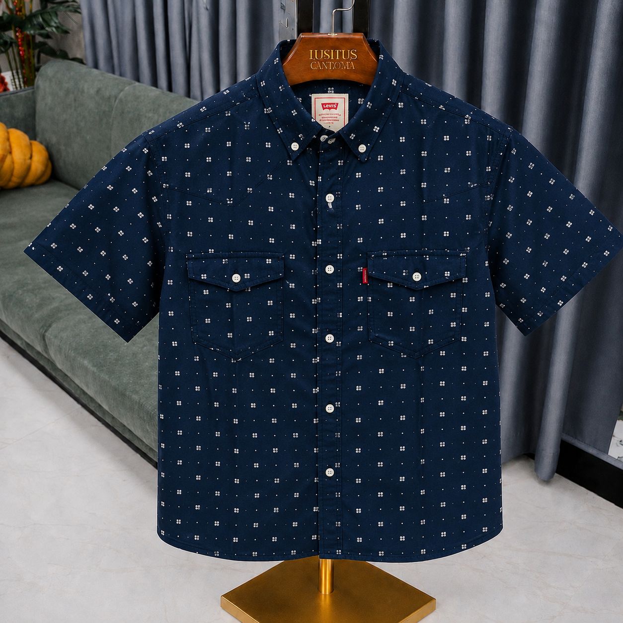 A short-sleeve button-up shirt by Levi's in navy blue with a small white geometric pattern, displayed on a wooden hanger on a mannequin stand in a living room setting.