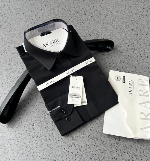 Black dress shirt with Arare label on a gray surface