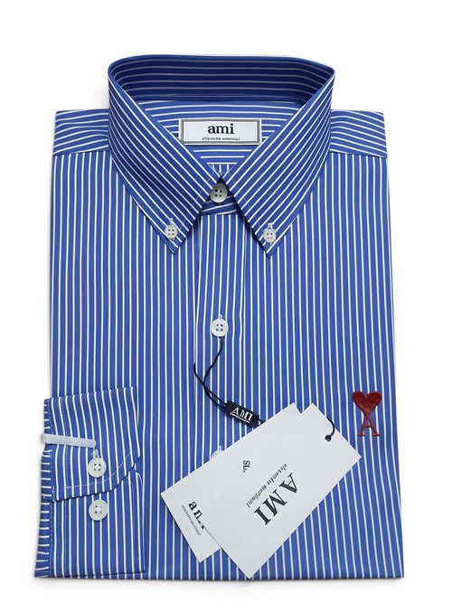 A folded blue and white striped dress shirt with a button-down collar, white buttons, a brand label reading 'ami', and a white hangtag, shown on a plain white background.