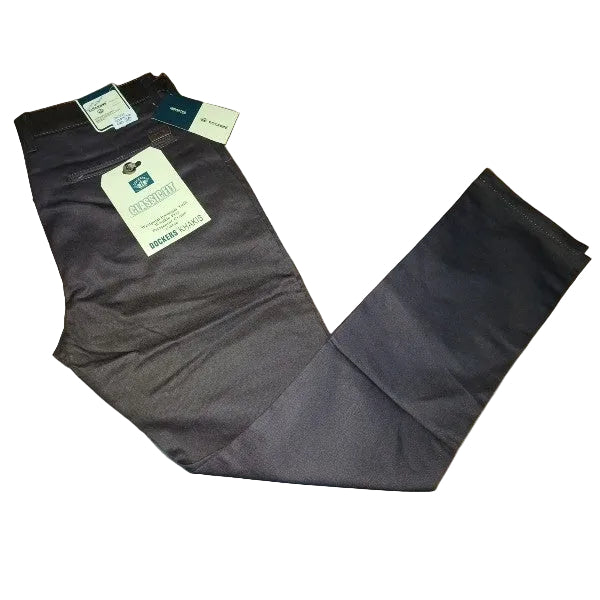 A pair of dark gray chino pants laid flat on a light wood floor, with retail tags still attached at the waistband.