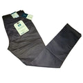 A pair of dark gray chino pants laid flat on a light wood floor, with retail tags still attached at the waistband.