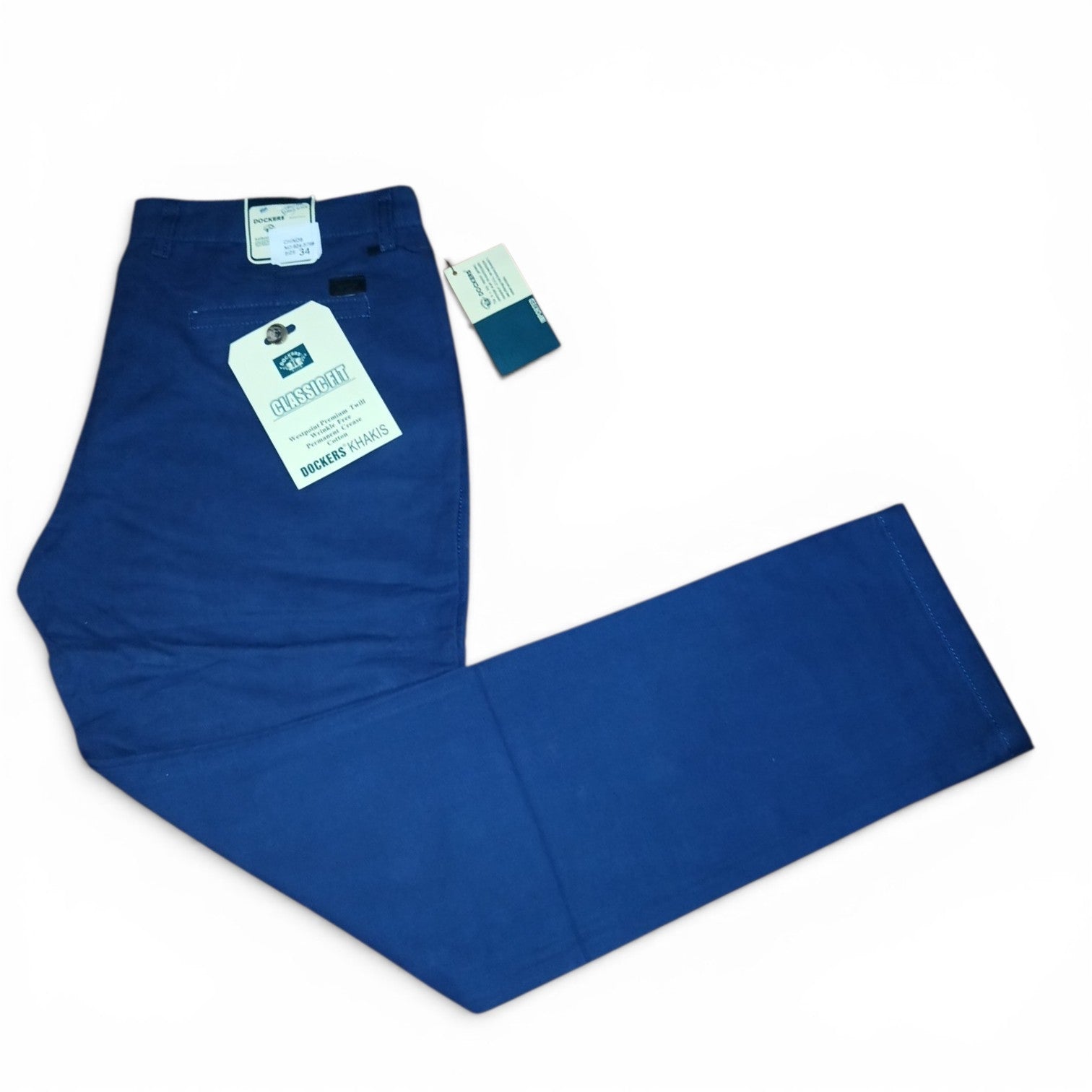 A pair of blue denim jeans laid flat on a white background, showing the back waistband with a paper hangtag and a smaller product tag attached.