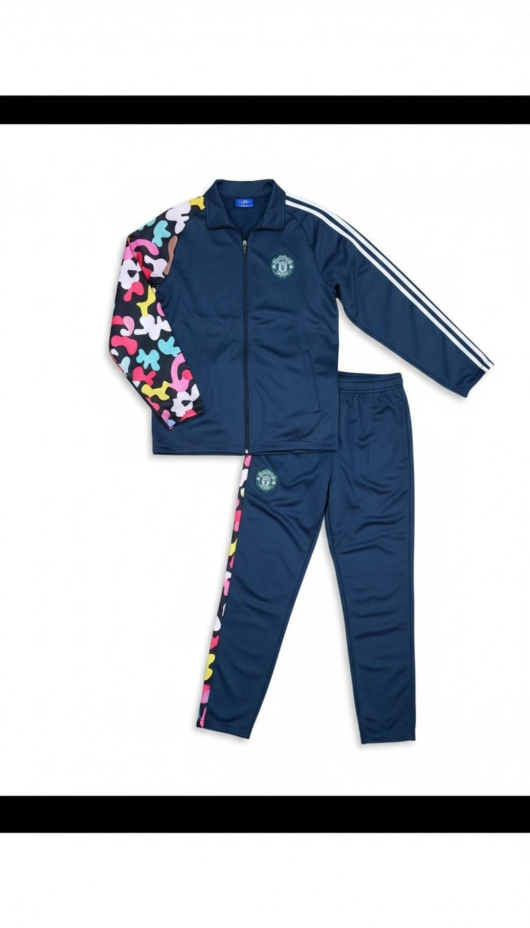 A two-piece kids' tracksuit set in navy blue, featuring a zip-up jacket with white stripes on the sleeves and a colorful abstract pattern on one sleeve, paired with matching navy pants with a multicolor pattern down the side.